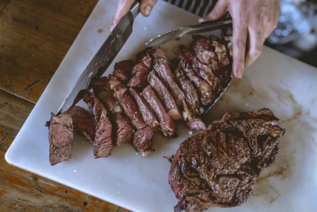 Close-Up Shot of a Person Slicing Cooked Meat