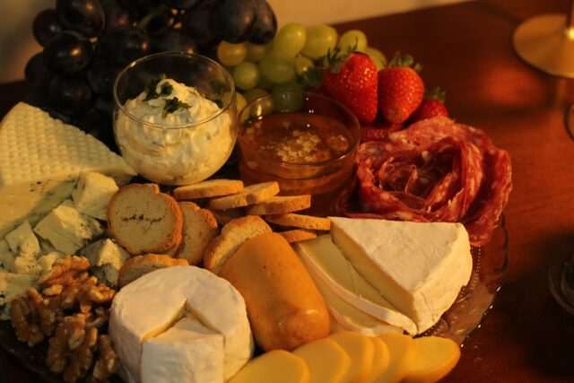 Photo by Andrei Marinho 1 a platter of cheese, crackers, fruit and nuts