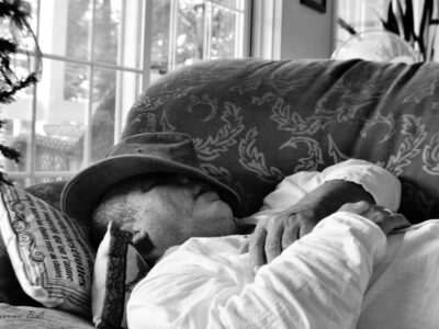 What Are The Habits That Ruin Your Sleeping? 10 a man sitting on a couch wearing a hat