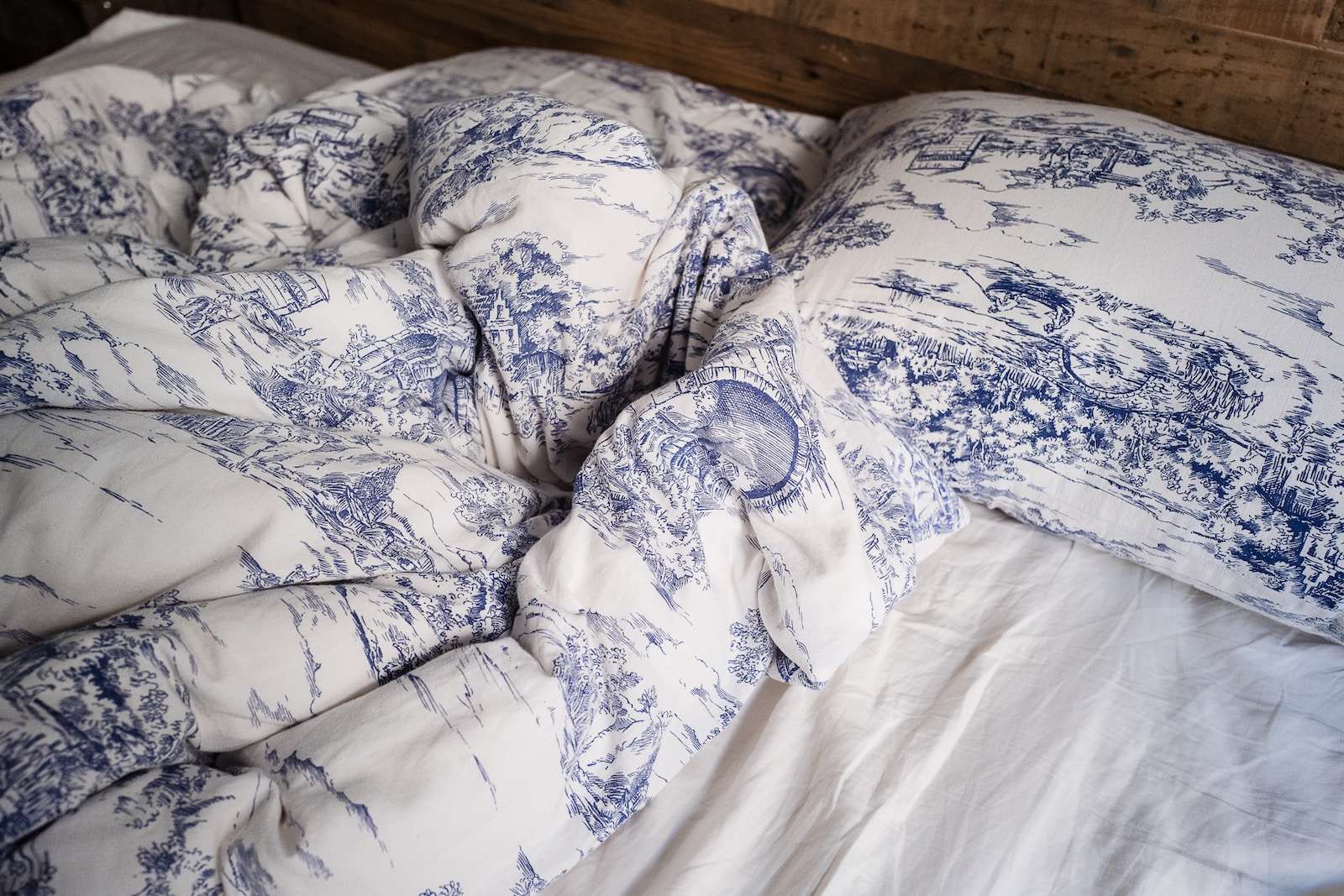 Photo by Jenna Christina blue and white pillow on white bed