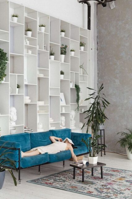 man in blue t-shirt lying on blue sofa