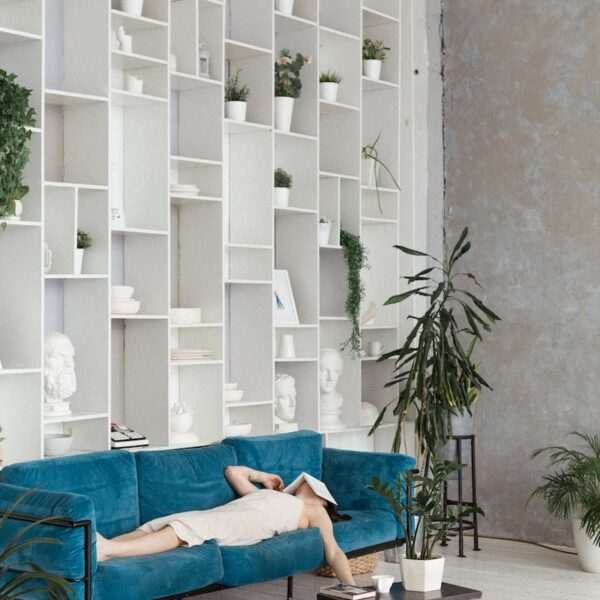 man in blue t-shirt lying on blue sofa