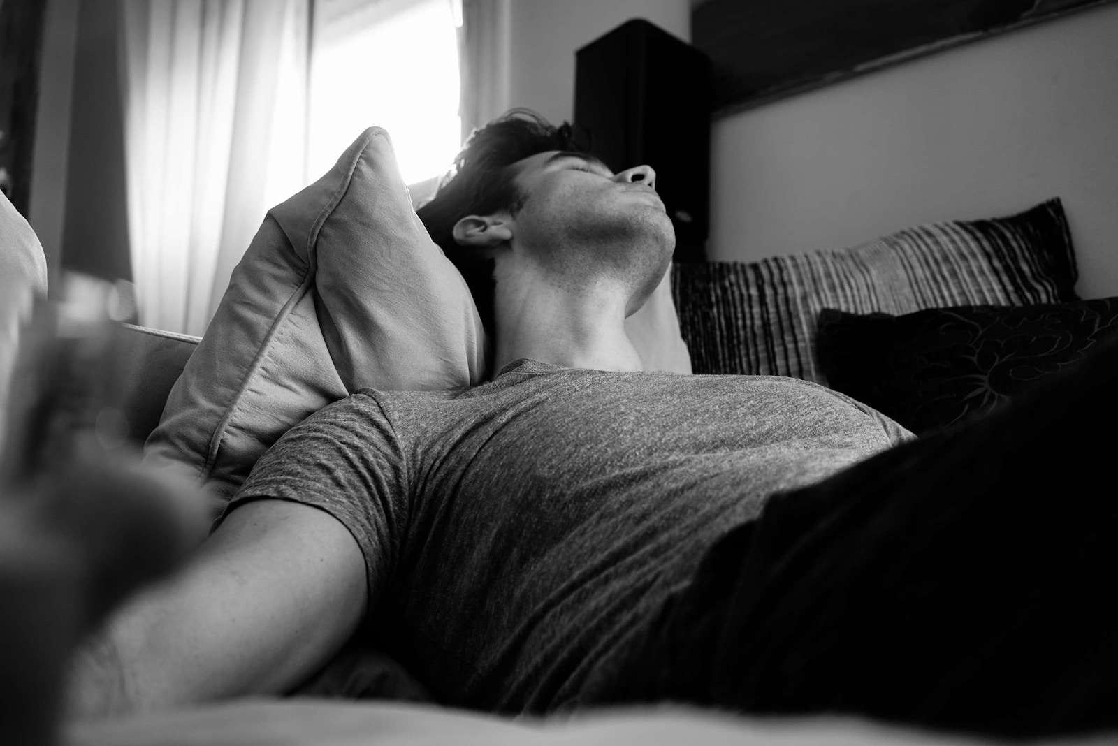 Photo by Adi Goldstein grayscale photo of man laying on bed