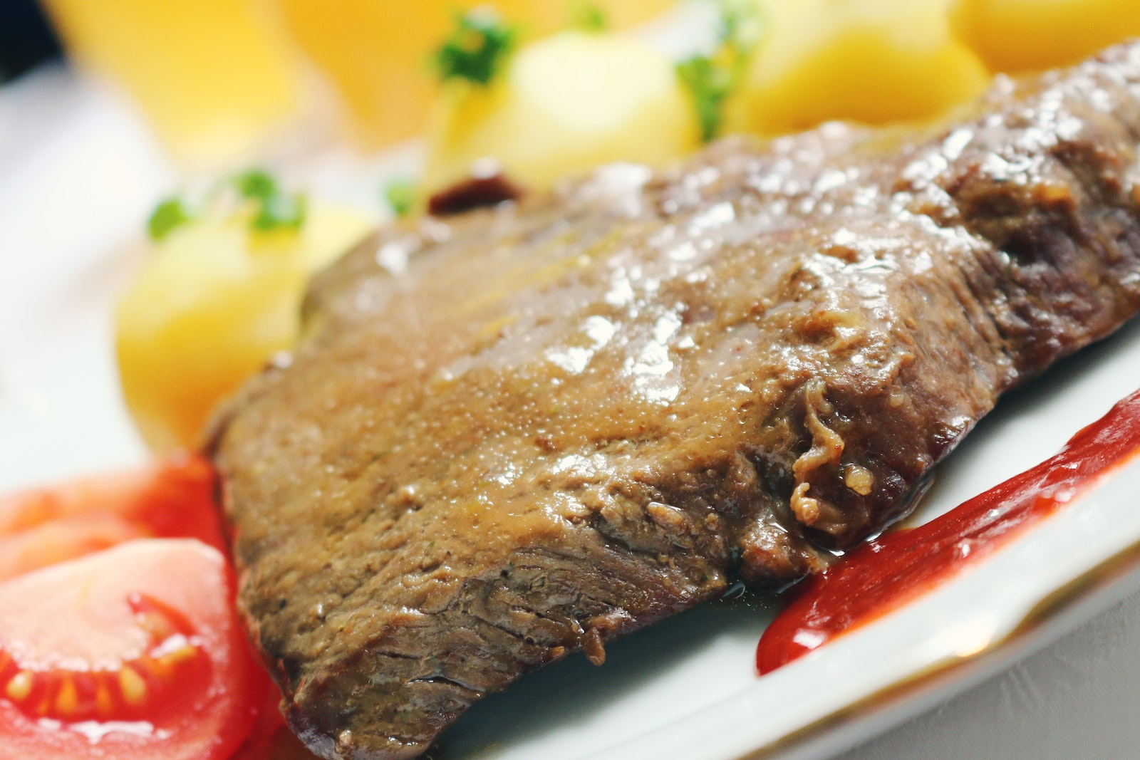 Roasted Meat With Red Sauce on White Ceramic Plate