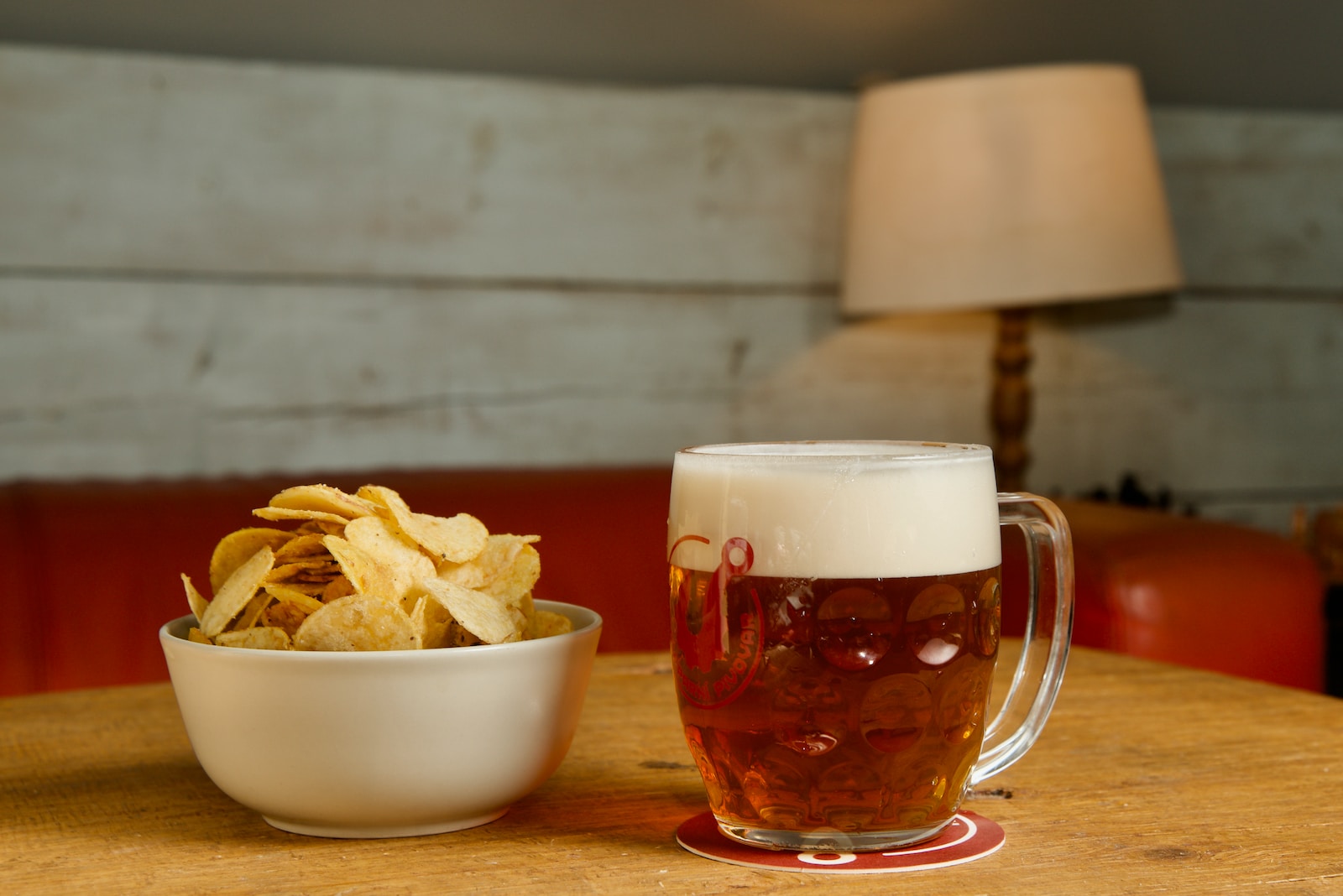 a bowl of chips and a beer on a table