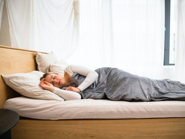 a man laying on a bed with a blanket on top of it
