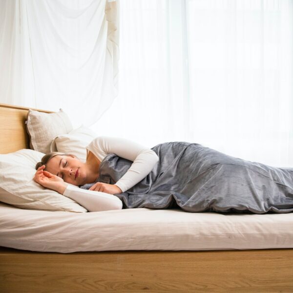 a man laying on a bed with a blanket on top of it