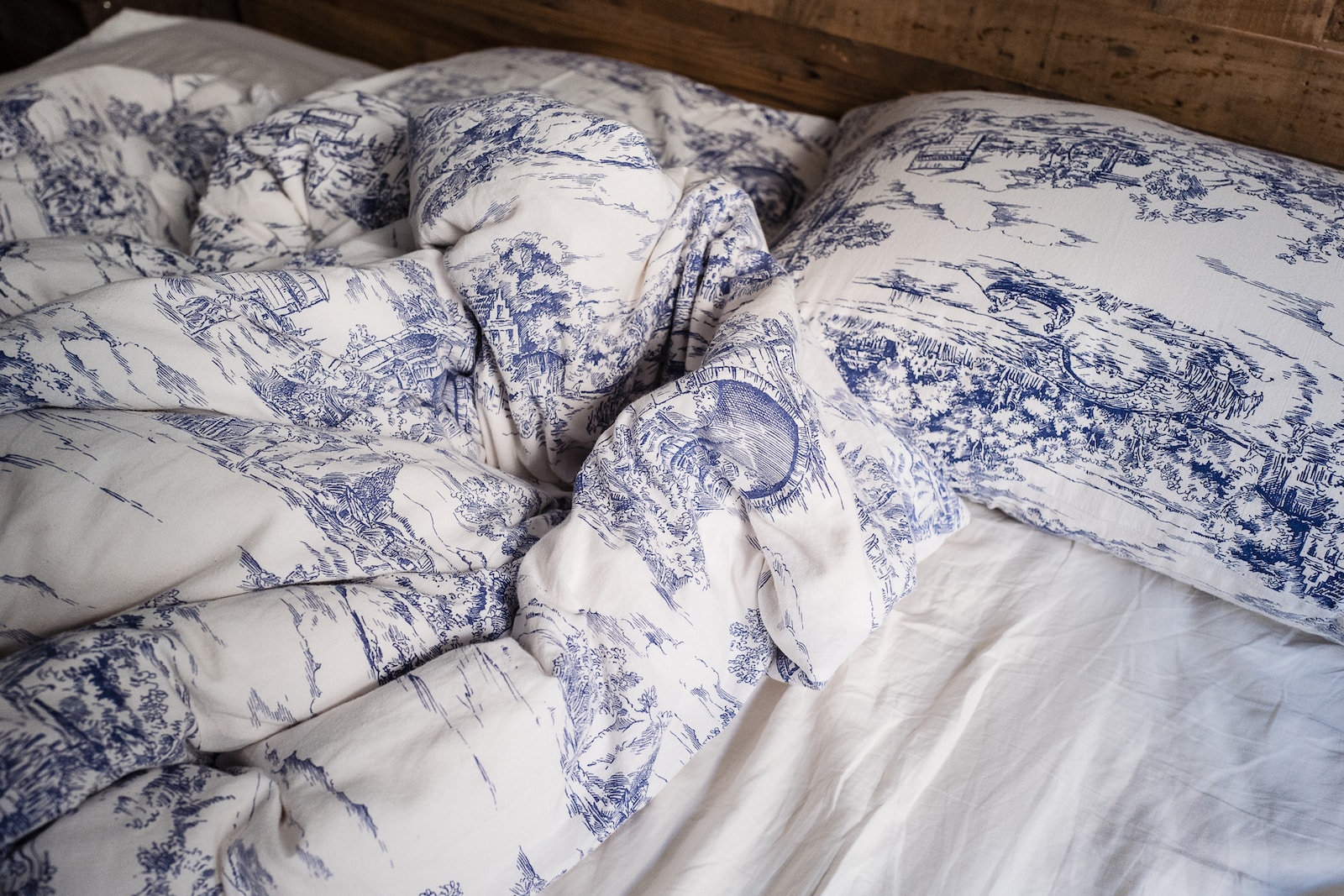 blue and white pillow on white bed